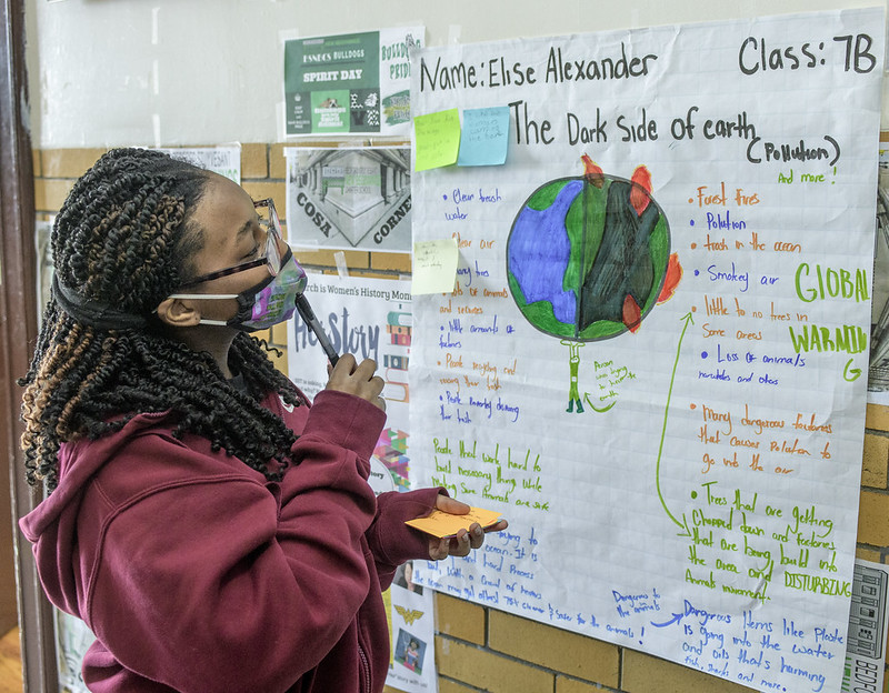 A student stands in front of a bulletin board at a Bedford Stuyvesant New Beginnings Charter School