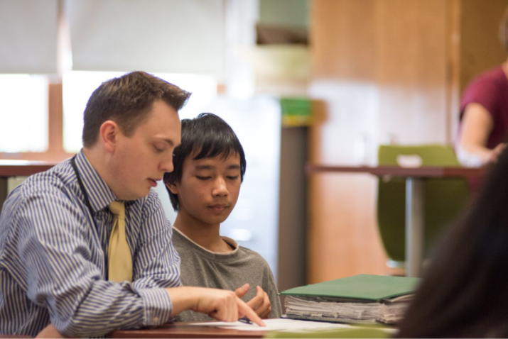 A Syracuse, NY student and teacher resident work together in a classroom