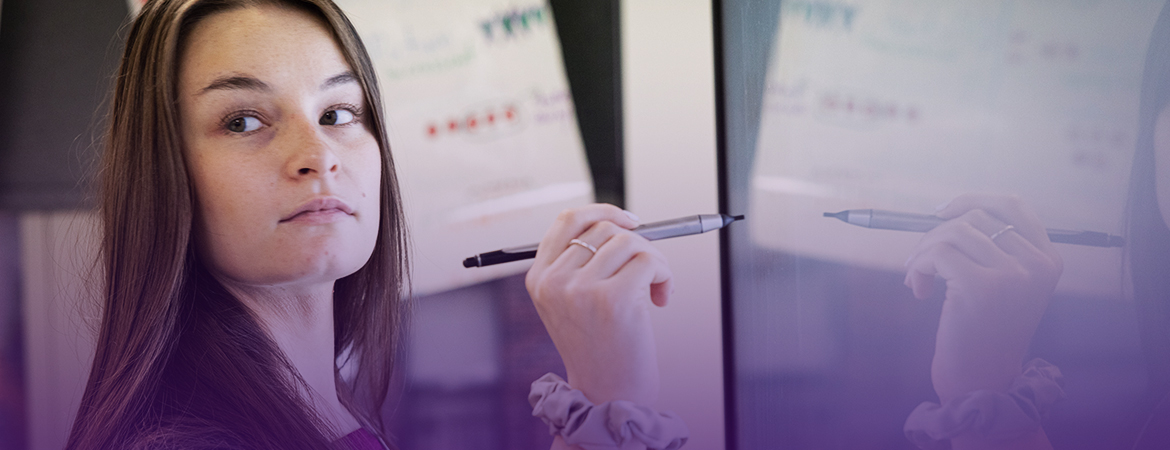 Resident writing on a whiteboard in her residency classroom.