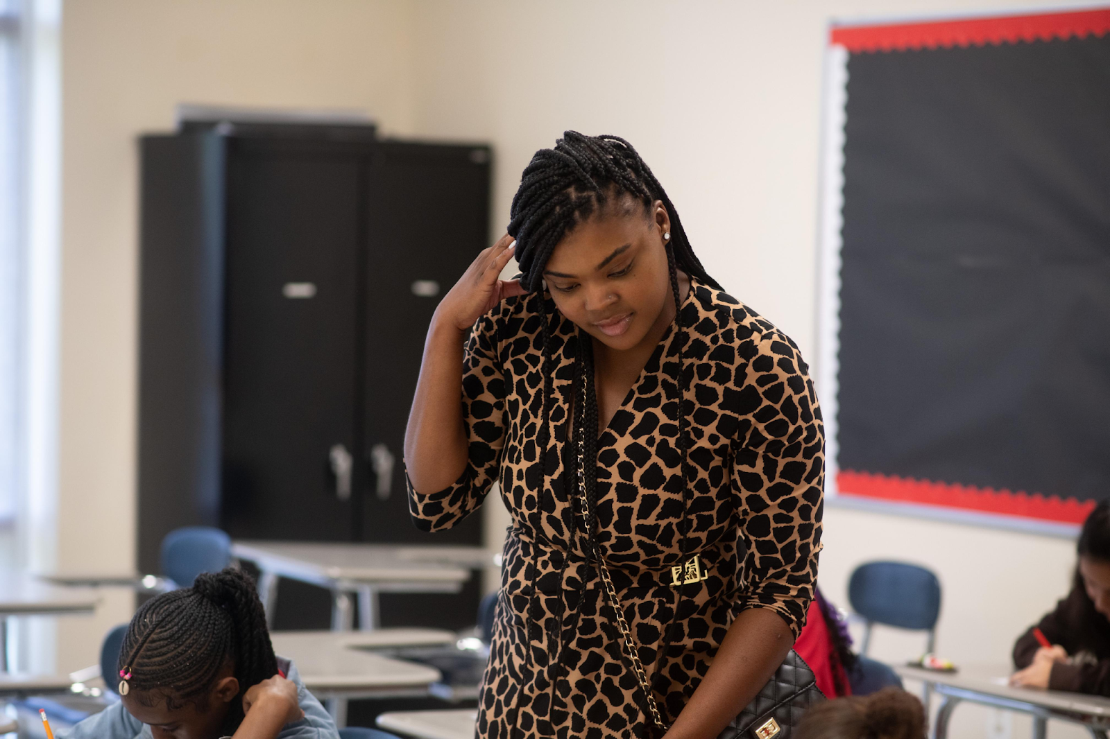 A teacher from Cesar Chavez Public Charter Schools for Public Policy stands in her classroom and works with her students.
